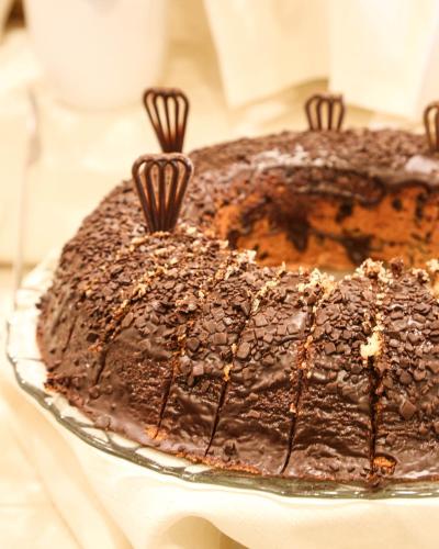 a chocolate cake on a glass plate on a table at Hotel Stella Del Mare in Cervia