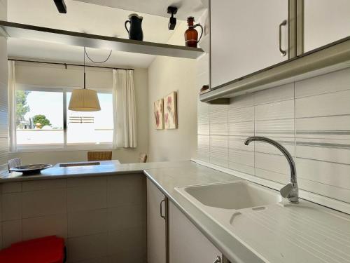 cocina blanca con fregadero y ventana en Ava Senia 4-1, en Begur