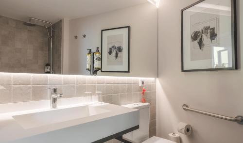 uma casa de banho branca com um lavatório e um espelho em Pousada Alfama em Lisboa