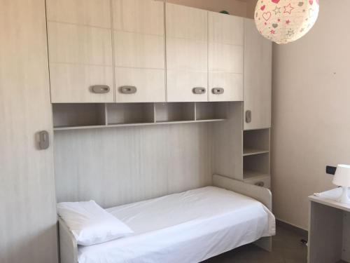 Casa Costa Outlet 2 في سيرافالي سكريفيا: غرفة نوم صغيرة بها سرير ودواليب بيضاء