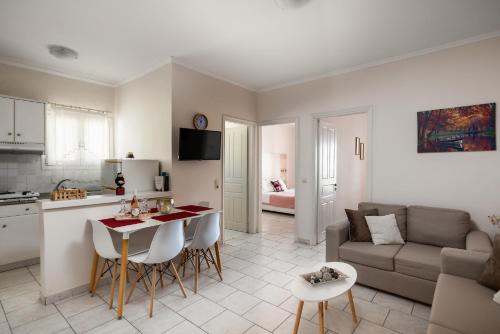 cocina y sala de estar con mesa y sofá en Albatross Apartments by Konnect, Ipsos Corfu, en Ýpsos