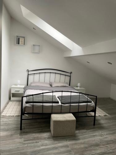 una camera bianca con letto e sgabello di Apartman Rakovac a Karlovac