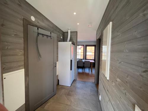 a hallway with a white refrigerator and a dining room at Salmons väg Funäsdalen in Funäsdalen