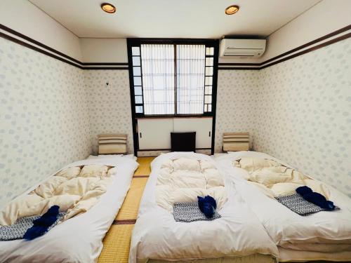 due ampi letti in una stanza con finestra di JAS HOTEL TAKAYAMA a Takayama