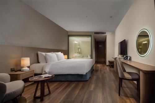 a hotel room with a large bed and a desk at Flamingo Resort Cat Ba in Cat Ba