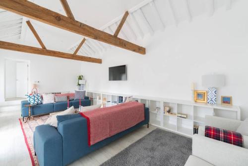 a living room with two blue couches in a attic at Simple Coastal Luxury near Southwold sleeps 10 in Southwold