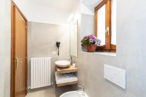 een badkamer met een wastafel, een toilet en een spiegel bij Perla in Spello