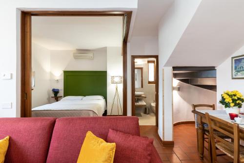 een woonkamer met een rode bank en een bed bij Perla in Spello