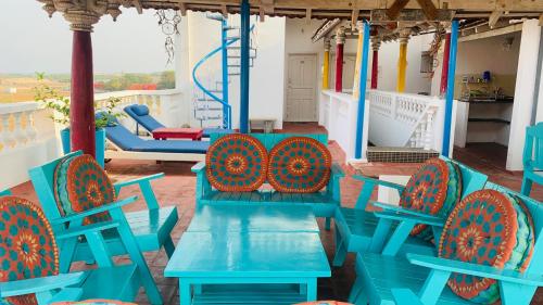 a group of blue tables and chairs on a porch at Holi-Wood Guesthouse in Pondicherry