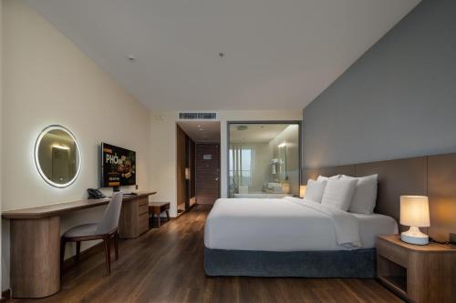 a hotel room with a bed and a desk and a computer at Flamingo Resort Cat Ba in Cat Ba