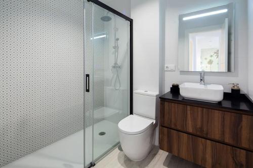 La salle de bains est pourvue d'une douche, de toilettes et d'un lavabo. dans l'établissement Stunning apartment in Nervion with parking, à Séville