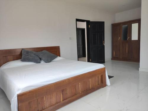 una camera da letto con un grande letto con lenzuola bianche di House in brufut near the sea / tanji bird reserve a Brufut