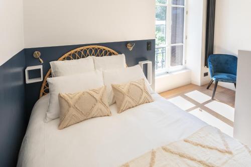 1 dormitorio con 1 cama con sábanas y almohadas blancas en Studio standing 3* Le Bernascon, en Aix-les-Bains