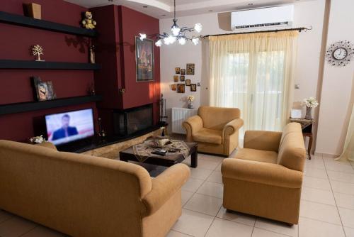 a living room with couches and a flat screen tv at House with Garden near the Beach in Heraklio