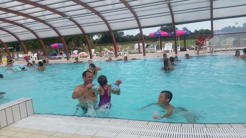 un groupe de personnes dans une piscine dans l'établissement Normandie 3 chambres Plages débarquement Mobile home, à Litteau
