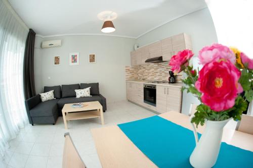 sala de estar con sofá y mesa con flores en Apartments More, en Perea