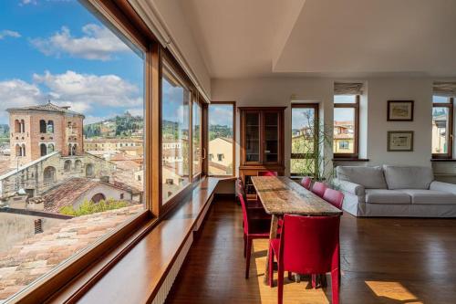ein Wohnzimmer mit einem Tisch und großen Fenstern in der Unterkunft Domus Verona - Residenza Ponte Pietra in Verona