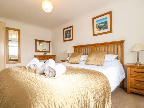 a bedroom with two beds with towels at Trewenna in Helston