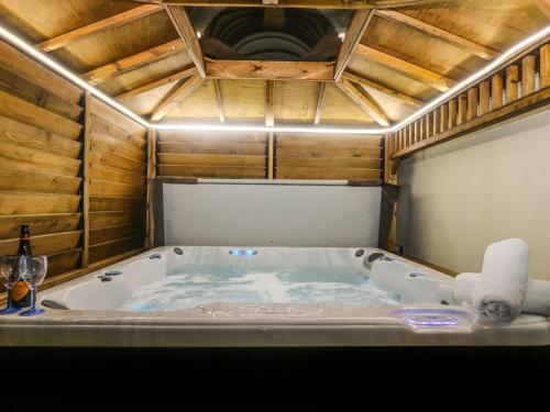 a jacuzzi tub in a room with wooden walls at Trewenna in Helston