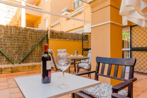 Una botella de vino sentada en una mesa con una copa de vino en Apartamentos O2 El Puerto, en El Puerto de Santa María