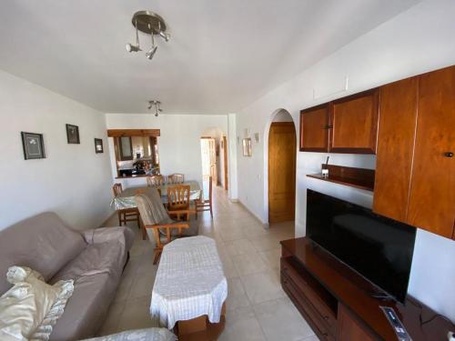 sala de estar con sofá, TV y mesa en Apartamento en la costa de Almería ( Palomares ) en Palomares