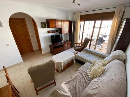 sala de estar con sofá y TV en Apartamento en la costa de Almería ( Palomares ) en Palomares