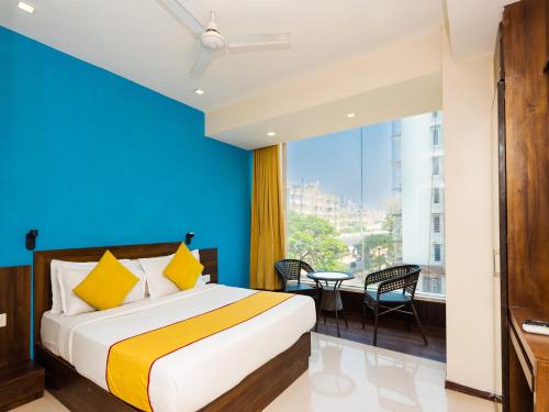 a bedroom with a bed and a large window at Hotel Aura - Near Malad Link Road in Mumbai