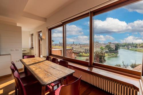 ein Esszimmer mit einem Tisch und einem großen Fenster in der Unterkunft Domus Verona - Residenza Ponte Pietra in Verona