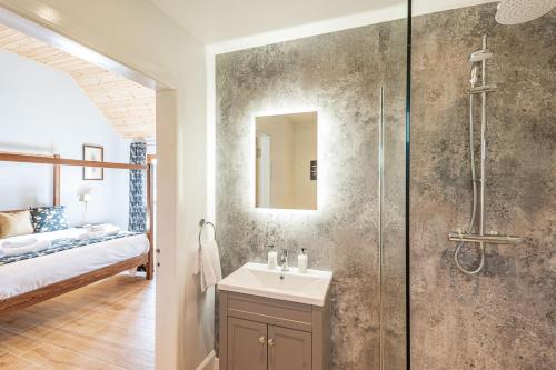 un bagno con doccia, lavandino e specchio di Kestrel Lodge 3 with Hot Tub a Newton Stewart