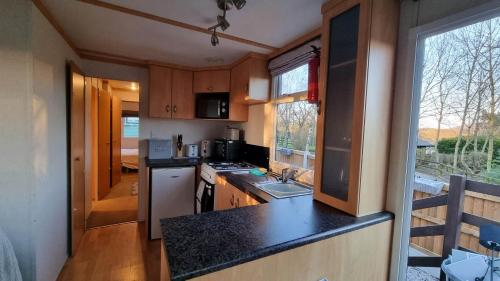 uma pequena cozinha com um balcão preto em Wyreside Lakes Glamping Pods em Lancaster