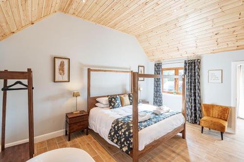 a bedroom with a bed and a wooden ceiling at Kestrel Lodge 3 with Hot Tub in Newton Stewart