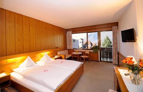 a hotel room with a bed and a desk and a television at Frühstückspension Appartement Südtirolerhof in Schenna