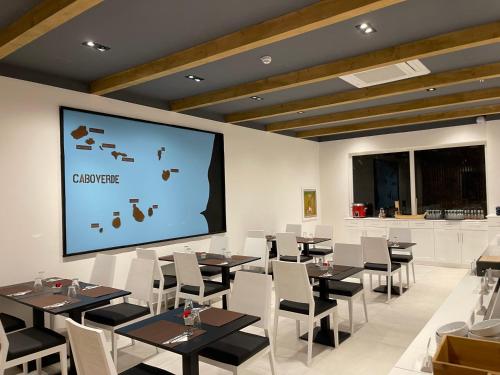 a conference room with tables and chairs and a projection screen at Oasis White Hotel in Sal Rei