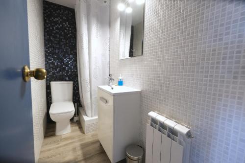 La salle de bains est pourvue de toilettes et d'un mur carrelé bleu. dans l'établissement La Brisa Marina, à Roda de Bará