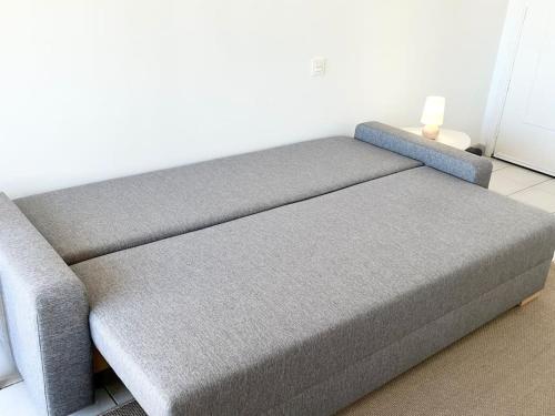 - un canapé gris dans une pièce dans l'établissement Hendaye plage charmant studio 2pers avec grande terrasse vue mer, à Hendaye