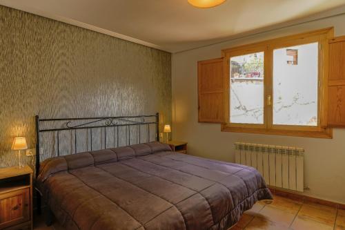sypialnia z łóżkiem i oknem w obiekcie Barranco de la Olla by Apartamentos Arnedillo w mieście Arnedillo