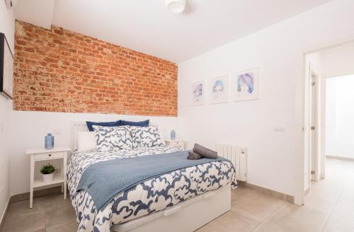 um quarto com uma cama e uma parede de tijolos em Duplex in the center of Madrid (B2) em Madri