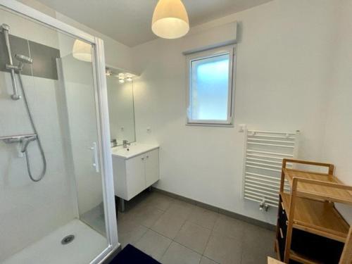 une salle de bain blanche avec une douche et un lavabo dans l'établissement Quiberon: Appartement 3 pièces, 65m², à deux pas des plages, terrasse, WIFI inclus - FR-1-478-25, à Quiberon