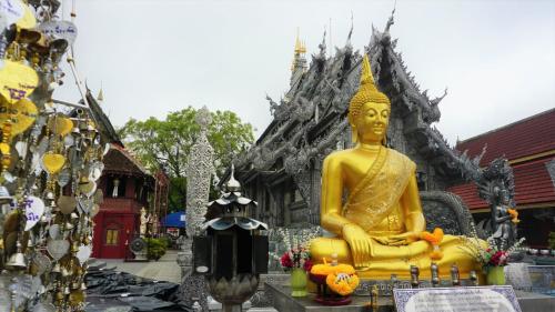 a large gold statue in front of a building at iWualai Hotel in Chiang Mai