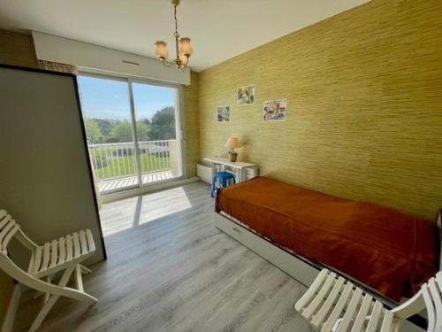 une chambre avec un lit et une grande fenêtre dans l'établissement Quiberon - Appartement 3 pièces avec balcons, animaux admis - FR-1-478-242, à Quiberon