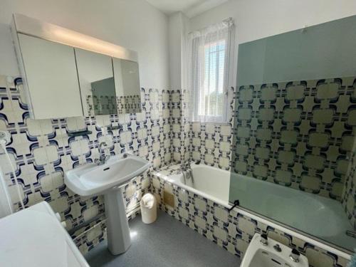 ein Badezimmer mit einem Waschbecken, einer Badewanne und einem Waschbecken in der Unterkunft Appartement Quiberon, 3 pièces, 4 personnes - FR-1-478-242 in Quiberon