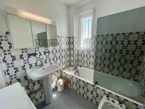 une salle de bain avec un lavabo et une baignoire et un lavabo dans l'établissement Quiberon - Appartement 3 pièces avec balcons, animaux admis - FR-1-478-242, à Quiberon