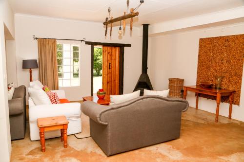 a living room with a couch and a stove at Landor Stud Farm Cottage in Magaliesburg