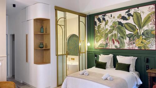 una camera da letto con un letto e un quadro sul muro di Home Chic Home - Les Suites de La Comédie a Montpellier