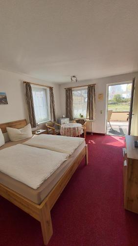 1 dormitorio con 2 camas en una habitación con alfombra roja en Pension Hanni, en Ostseebad Sellin