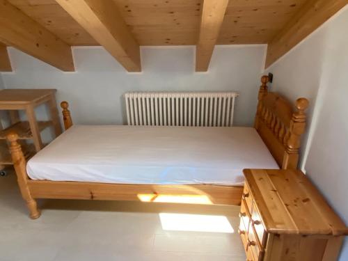 una camera con letto in legno e tavolo in legno di Bait dal Molin Florin a Livigno