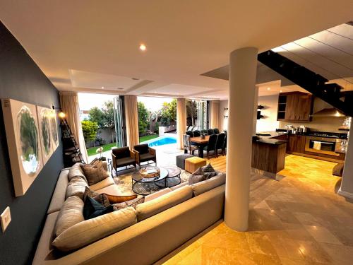 a living room with a large couch and a kitchen at One On Houghton in Cape Town