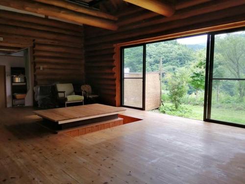 にあるkaso Space kamiyama Log Houseのウッドフロアの客室で、大きな窓が付いています。