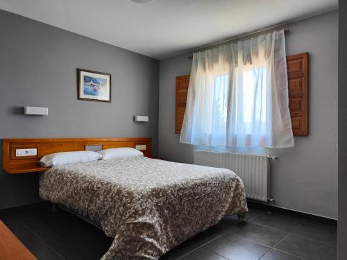 a bedroom with a bed and a window at Hotel Puerta de Javalambre in La Puebla de Valverde