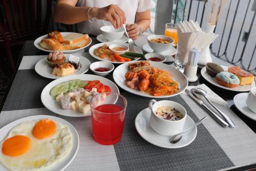 a table with plates of breakfast food on it at Hotel Del Luna Boutique in Da Nang